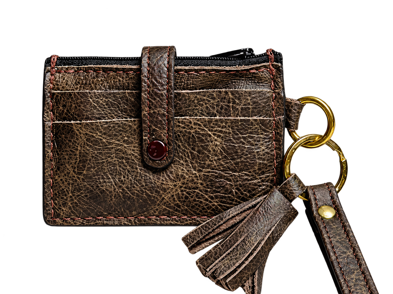 Dark brown full-grain leather wristlet wallet with front card slots, gold-tone rings, tassel and matching wrist strap.Copy filename