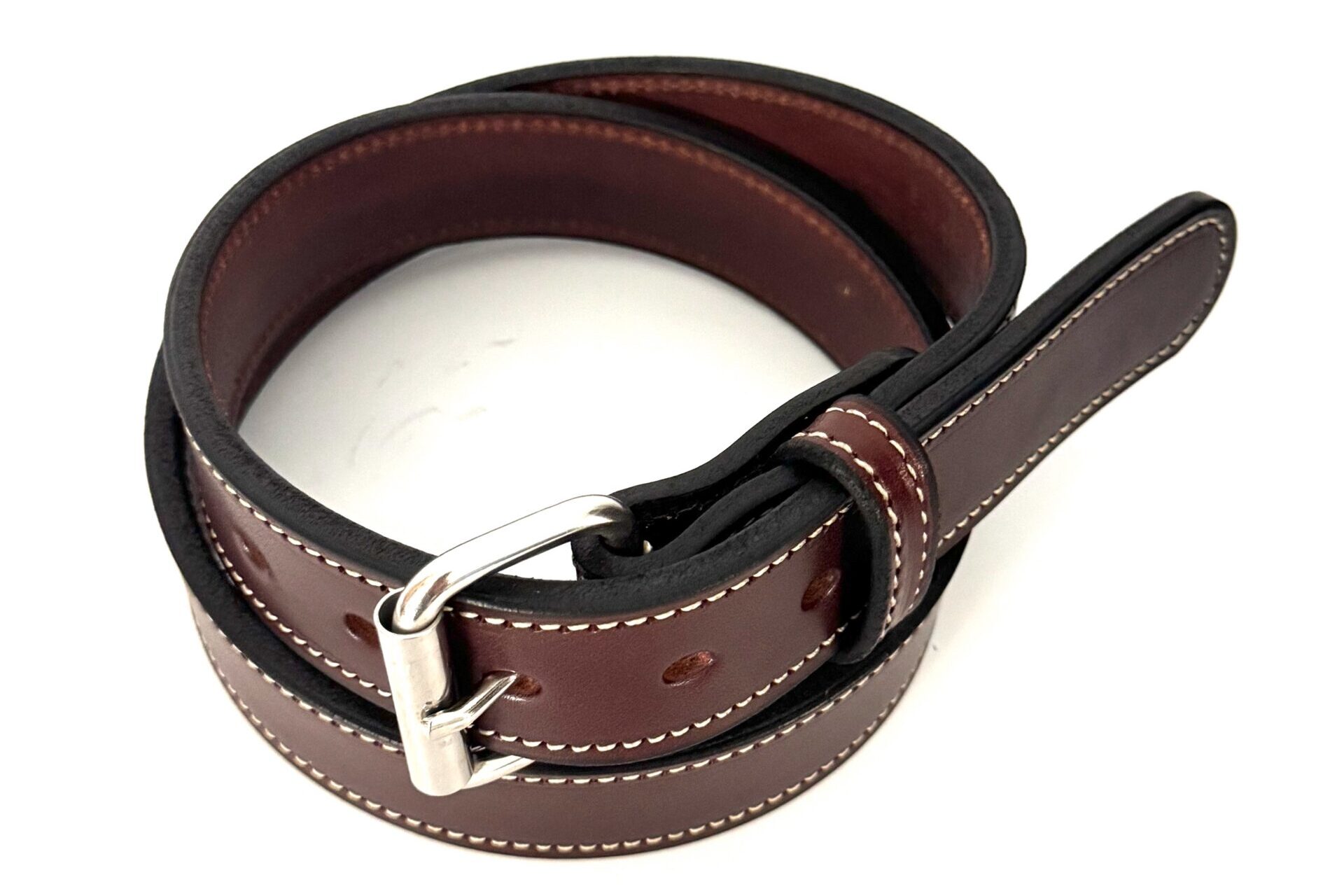 Angled view of brown heavy leather belt with white contrast stitching