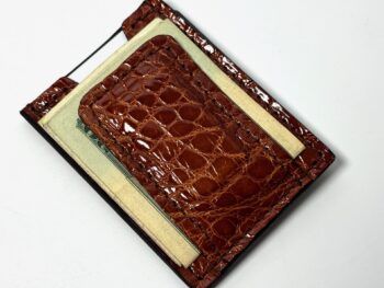 Cognac alligator leather money clip wallet shown from the front with cash secured beneath the center clip.