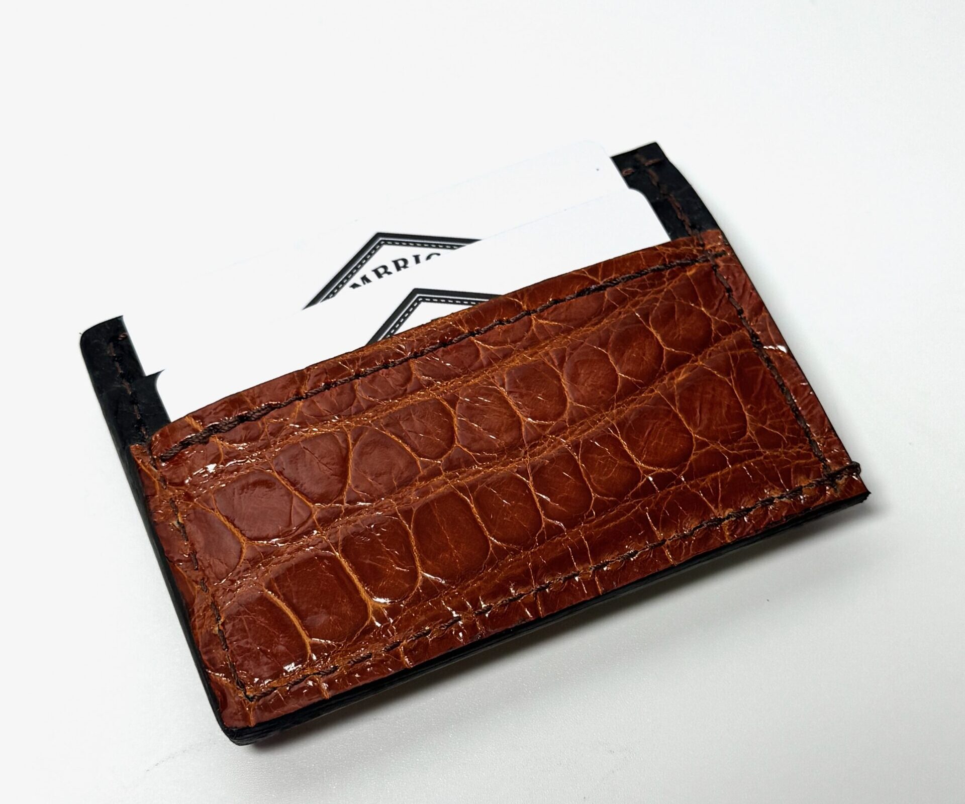 Angled view of the cognac alligator leather money clip wallet showing the rear card holder with cards inserted.