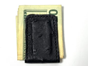 Black ostrich leather magnetic cash clip holding folded bills
