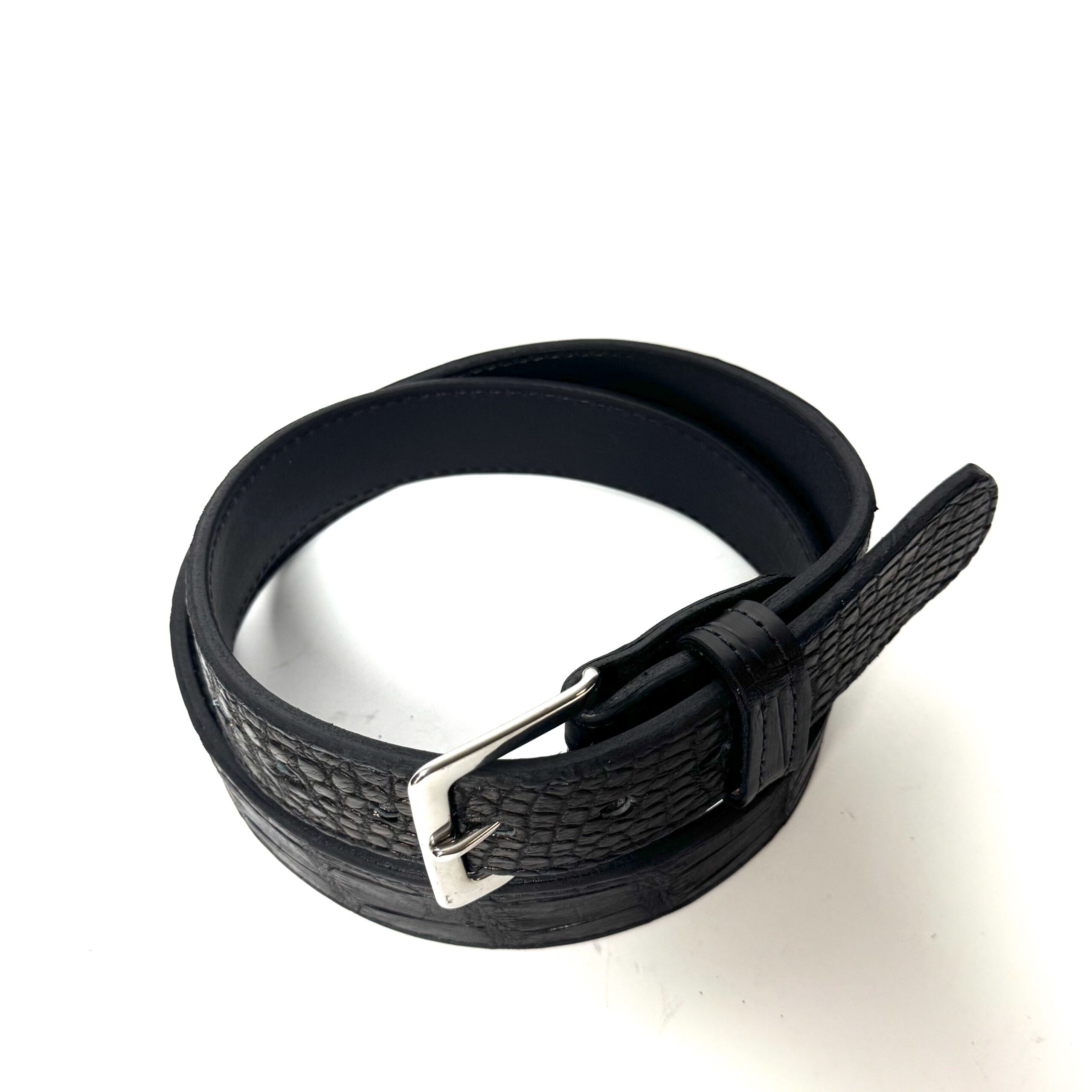 Angled view of black alligator leather belt with cowhide backing