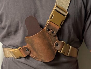 Brown water buffalo leather chest holster with adjustable nylon harness worn across chest